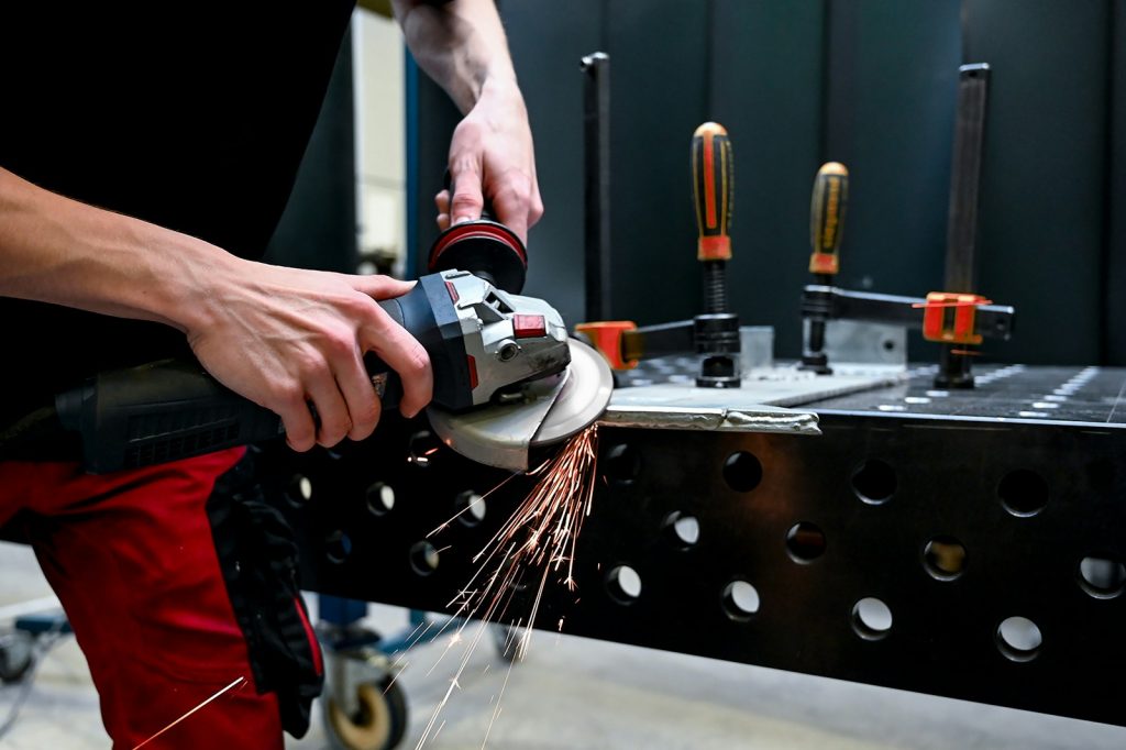 a man using a grinder on a piece of metal